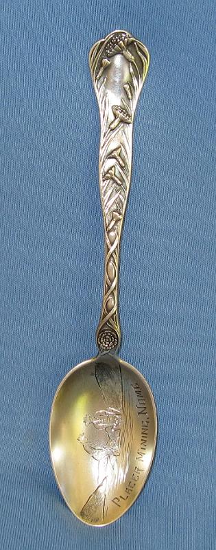 Souvenir Mining Spoon Nome Alaska.JPG - SOUVENIR MINING SPOON NOME ALASKA - Sterling silver souvenir spoon, engraved mining scene in bowl showing miners panning for gold, marked PLACER MINING, NOME, decorative design with flowers on handle, reverse marked Sterling with makers mark, 5 3/8 in. long  [The Nome mining district is a gold mining district in Alaska. It was discovered in 1898 when Erik Lindblom, Jafet Lindeberg and John Brynteson, the "Three Lucky Swedes", found placer gold deposits on Anvil Creek and on the Snake River, a few miles from the future site of Nome. News of the strike reached the gold fields of the Klondike that winter and by 1899 Anvil City, as the new camp was called, had a population of 10,000. It was not until gold was discovered in the beach sands in 1899 and news reached the outside that the real stampede was on. Thousands poured into Nome during the spring of 1900, as soon as steamships from the ports of Seattle and San Francisco could reach the north through the ice. In the treeless location, tents soon covered the landscape, reaching the water's edge, and extending most of the 30 miles between Cape Rodney and Cape Nome. Buildings of finished board lumber began going up as early as 1899, as soon as ships reached Nome from the states with supplies.  The town was locally known as Anvil City for much of 1899, but the United States Post Office Department insisted on calling the community Nome, apparently because it was thought that a town called Anvil City would be easily confused with the village of Anvik on the lower Yukon. A vote was held and the town’s merchants reluctantly agreed to change the name from Anvil City to Nome.  This was one of the first and was the biggest Alaskan gold rush in North America; only the California and Klondike stampedes were larger. A chaotic and lawless scene ensued, with rampant claim-jumping, crooked judges, and not enough gold found for the 20,000 prospectors, gamblers, shop and saloon-keepers, and prostitutes living in the tent city on the beachfront tundra, at least not at first. Then someone thought to pan the red-and-black streaked beach sands. Within days, gold was found for tens of miles up and down the beach from Nome. More than a million dollars' worth of gold was taken from the beach in 1899. Subsequently the second and third beach lines were discovered and mined. Anvil Creek produced the second-largest gold nugget found in Alaska (182 troy ounces).  Except while prohibited by law during WWII, placer mining near Nome has continued to this day. Over 3.6 million troy ounces of gold have been recovered from the creeks of the Nome District.  A myriad of small hard-rock gold deposits were exploited near Nome, but production was very small, compared to the placer deposits, and none of the hard rock mines operated for more than a few years.]